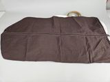 a brown bag on a white table with a brown handle