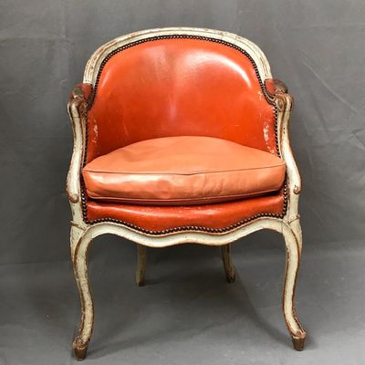 an orange and white chair with a leather seat on a grey background