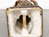an image of a statue of a man laying in a suitcase