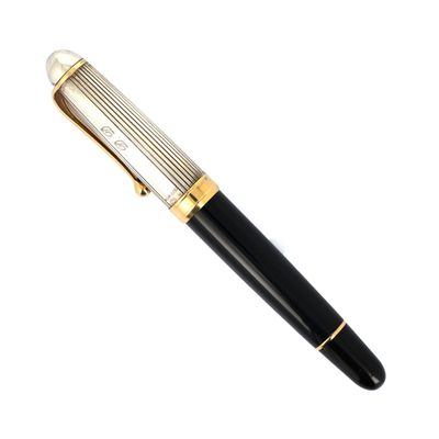 un stylo noir et or posé sur une surface blanche