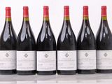 six bouteilles de vin sont alignées sur une table