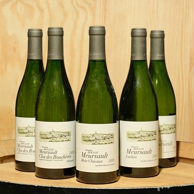 quatre bouteilles de vin sont alignées sur un tonneau en bois
