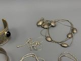 a lot of silver jewelry sitting on a table