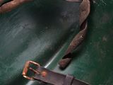 a green helmet that has a leather strap on it