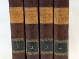 trois livres sont empilés sur une surface blanche