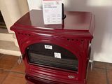 a small red stove with a menu on top of it