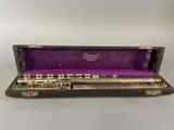 an old flute in a case with a purple velvet lining
