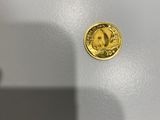 gros plan d'une pièce d'or sur une surface blanche