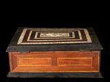 an old wooden box with a black and white design on the lid