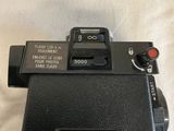 an old camera sitting on top of a table next to a cup of coffee