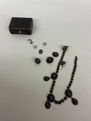 un collier noir, des boucles d'oreilles et une boîte posée sur une table