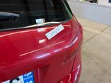 a sticker on the rear window of a red car