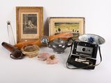une photo d'un appareil photo, une photo d'une photo, une photo d'un homme et d'une femme, ainsi que d'autres objets posés sur une table