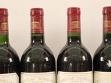 three bottles of red wine are lined up on a table