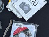 the contents of a camera, a camera case, a camera lens, a dvd, and other items on a table