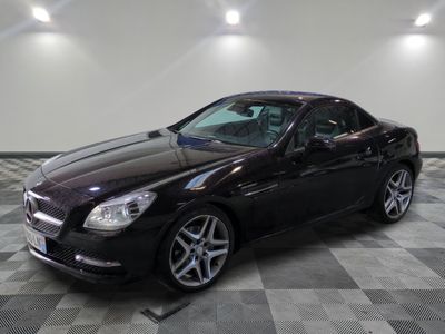 une photo d'une Mercedes SLK noire garée dans un garage