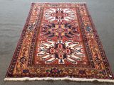 un tapis oriental posé au sol, orné d'un motif bleu et rouge