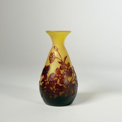 un vase jaune et noir posé sur une surface blanche