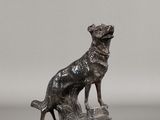 statue en bronze représentant un chien et un chat sur un rocher