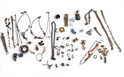 many different types of necklaces and bracelets laid out on a white surface