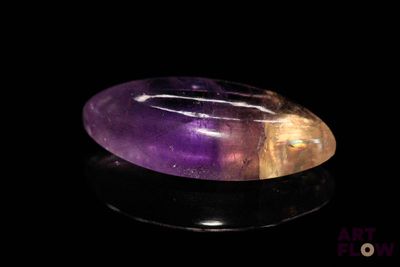 a close up of a purple and yellow quartz stone on a black surface