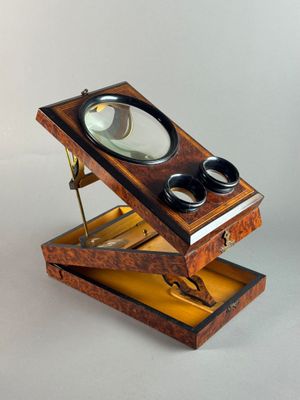 a small wooden box with a magnifying glass in it