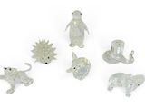 un ensemble de figurines d'animaux en verre posées sur une surface blanche