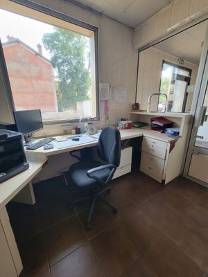 a desk with a computer and a printer in a room