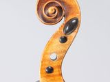 a close up of the back of a violin with a fiddle in the foreground
