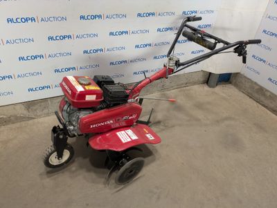 a red lawn mower sitting in front of a blue and white wall