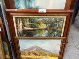Deux tableaux encadrés représentant un paysage de montagne sont exposés devant un bâtiment.