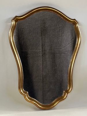 a gold framed mirror on a white wall with a black background