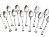 six silver spoons and two silver spoons on a white surface
