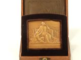 an image of a wooden box with a gold plaque in it