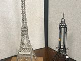 deux sculptures métalliques représentant la tour Eiffel, placées dans un coin de la pièce