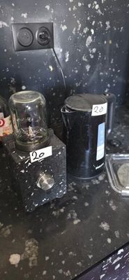 a black counter top with a blender and a glass container on it