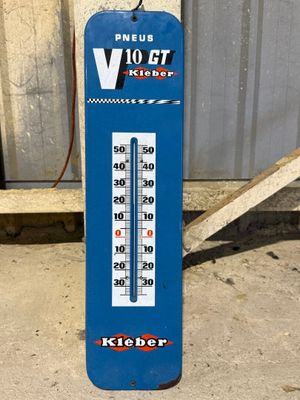 a blue and white thermometer sitting on the ground
