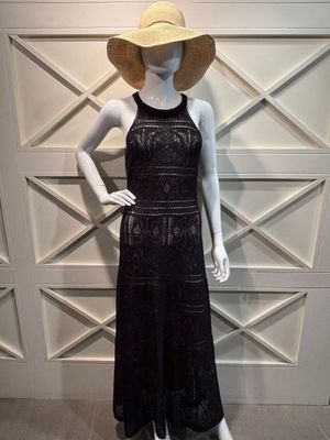 un mannequin vêtu d'une robe noire et d'un chapeau de paille