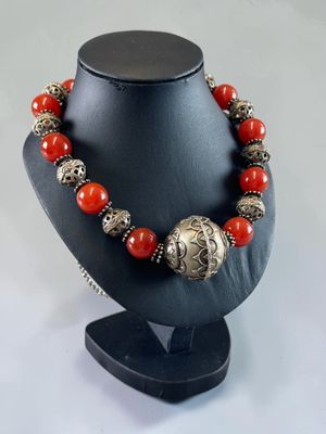 a close up of a necklace on a mannequin with red beads
