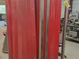 deux grands poteaux métalliques rouges dans un entrepôt séparé par un rideau rouge