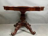 une vieille table en bois dont le plateau est sculpté sur fond blanc