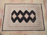 un tapis posé à même le sol, orné d'un motif noir et blanc