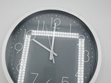a clock that is hanging on the wall with lights on it