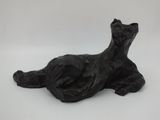 sculpture of a black cat laying down on a white surface