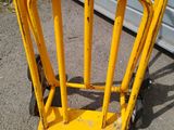 a yellow hand truck that is parked next to a garage
