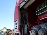 a red fire truck with a bunch of hoses in the back