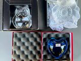 a glass owl figurine in a box next to other items