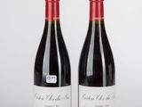 deux bouteilles de vin rouge posées l'une à côté de l'autre sur une table