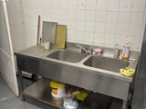 a kitchen with a sink and a trash can in it