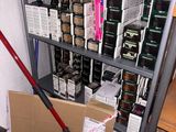 a cart full of boxes and a broom in the corner of the room
